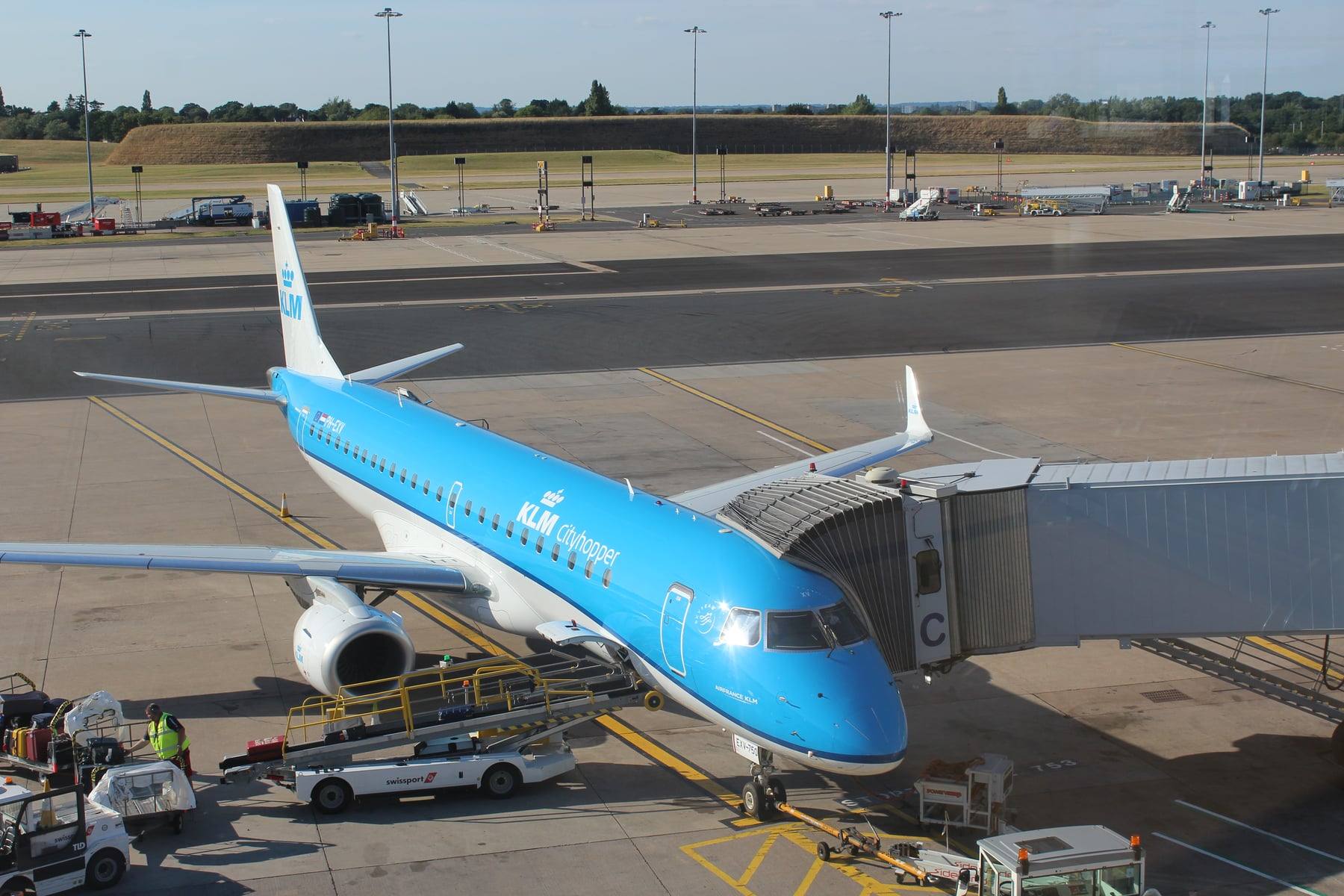 A KLM aircraft at a boarding gate with the jet bridge connected at Birmingham Airport